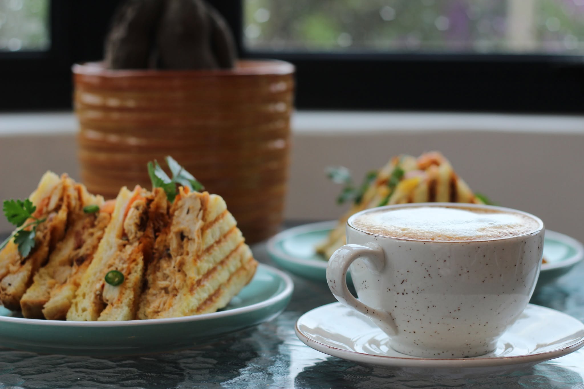 Cosy corner table with coffee and a toastie at Cafe 61